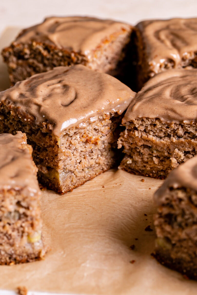 vertical shot of maple tahini banana bread bars sliced into squares spread out