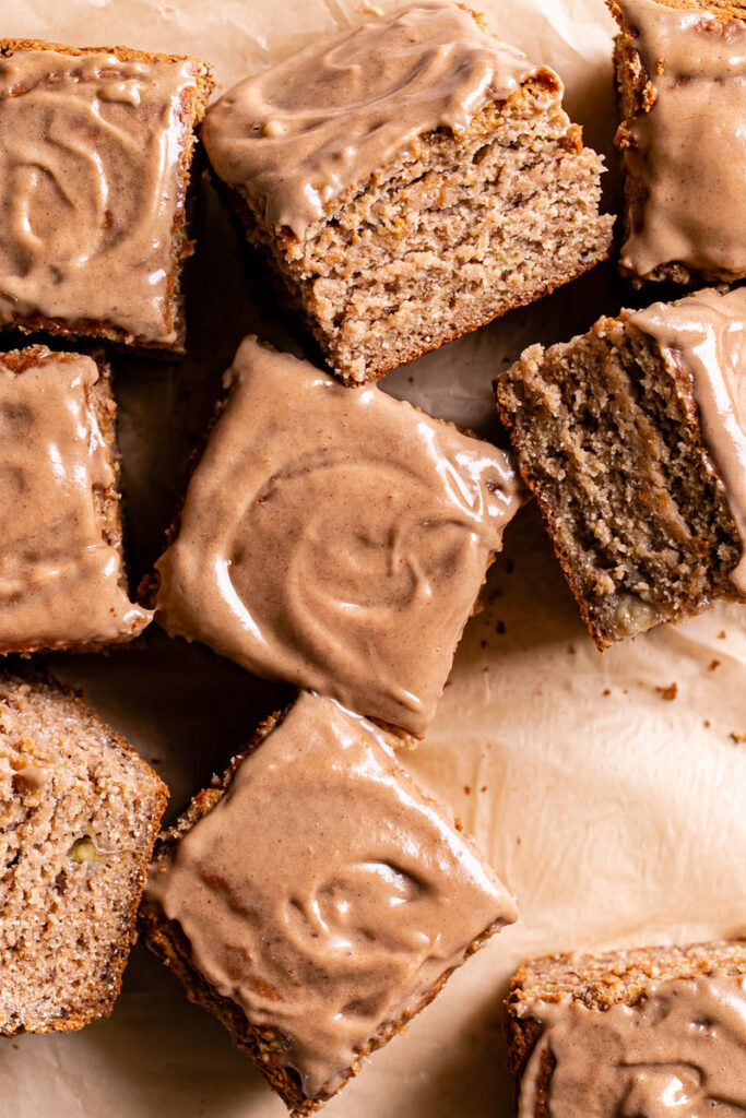 maple tahini banana bread bars sliced into squares and spread out on a piece of parchment paper