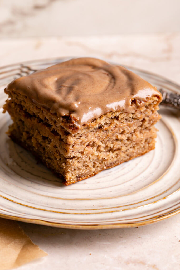a square slice of maple tahini banana bread bars on a plate with a fork on it