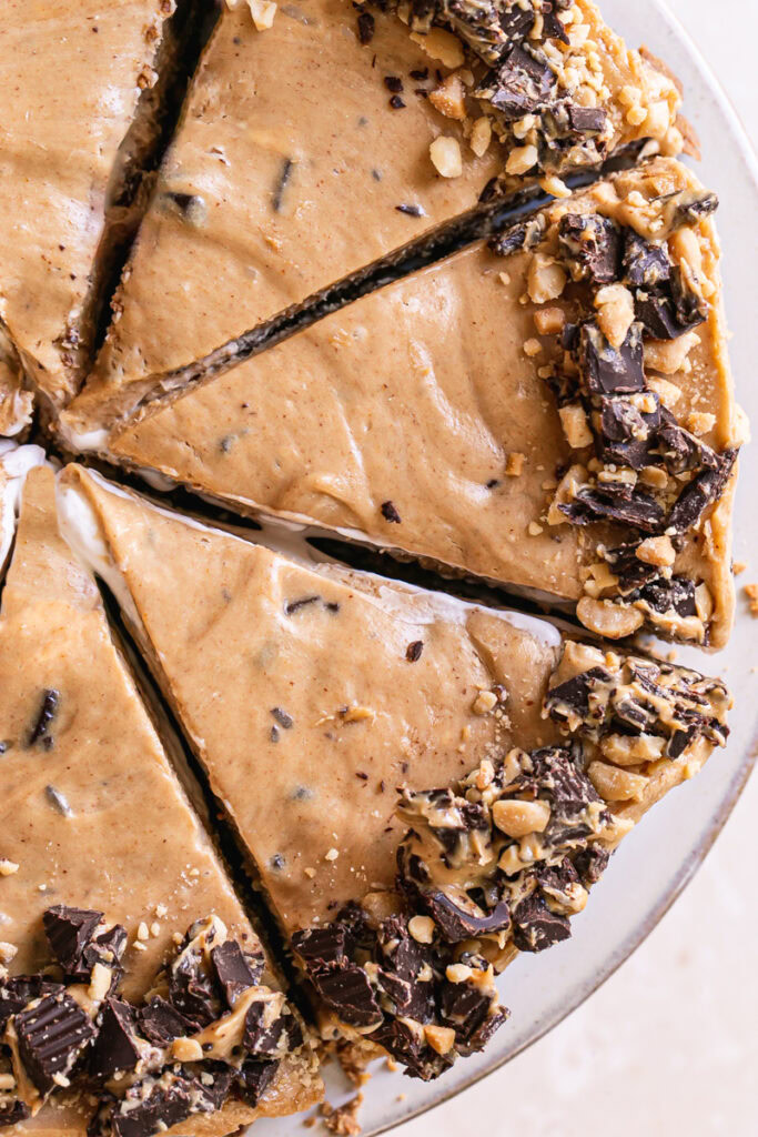 an overhead shot of sliced No-Bake Peanut Butter Cup Pie garnished with chopped peanut butter cups and peanuts