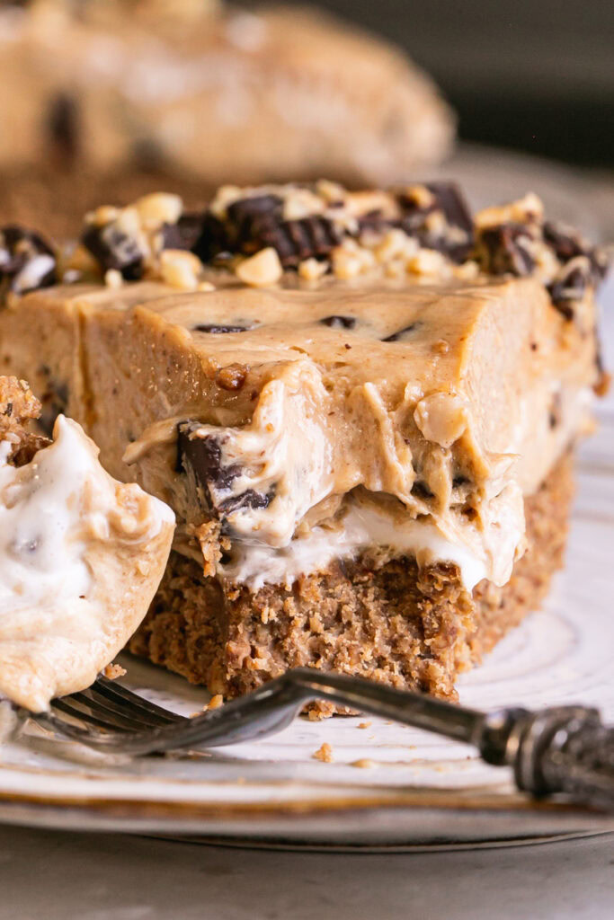 a close up of a slice of No-Bake Peanut Butter Cup Pie with a bite on a fork next to it
