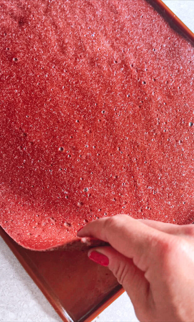 action shot of peeling the fruit leather off of the silicone mat