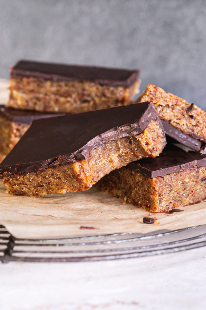 almond flour date cookie dough bars piled on top of one another, one with a bite taken out of it