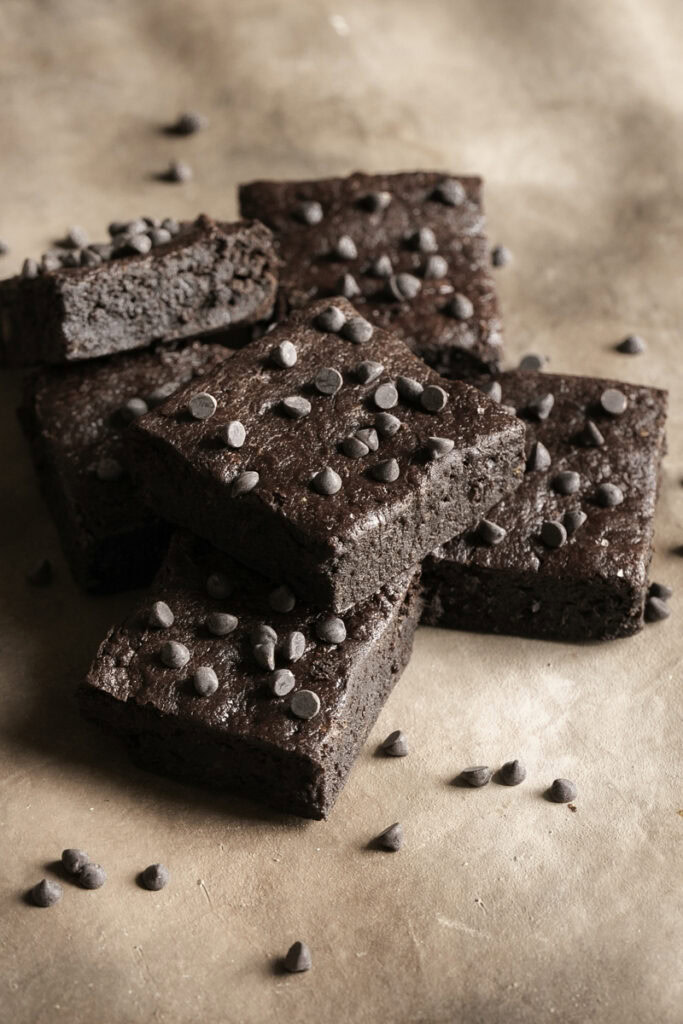 sliced fudgy flourless date brownies stacked on top of one another.