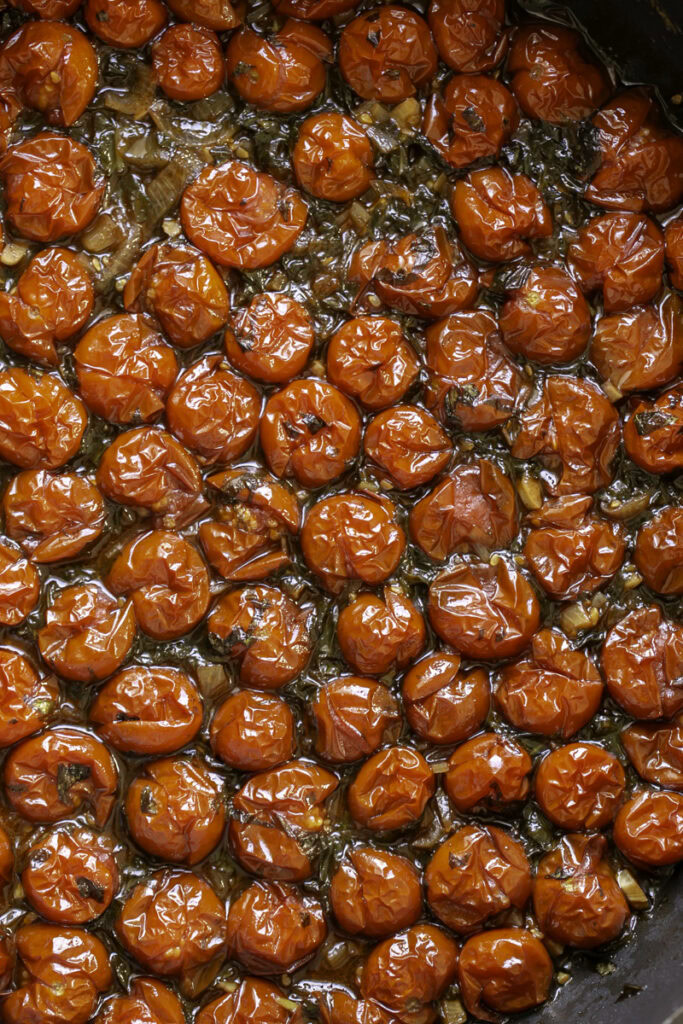 roasted burst cherry tomatoes in a skillet.