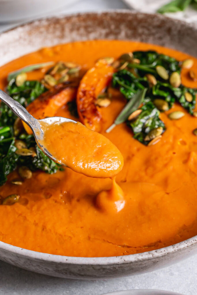 a close up action shot of a spoon scooping some soup out of the bowl