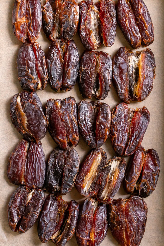 smashed dates on a parchment lined baking sheet