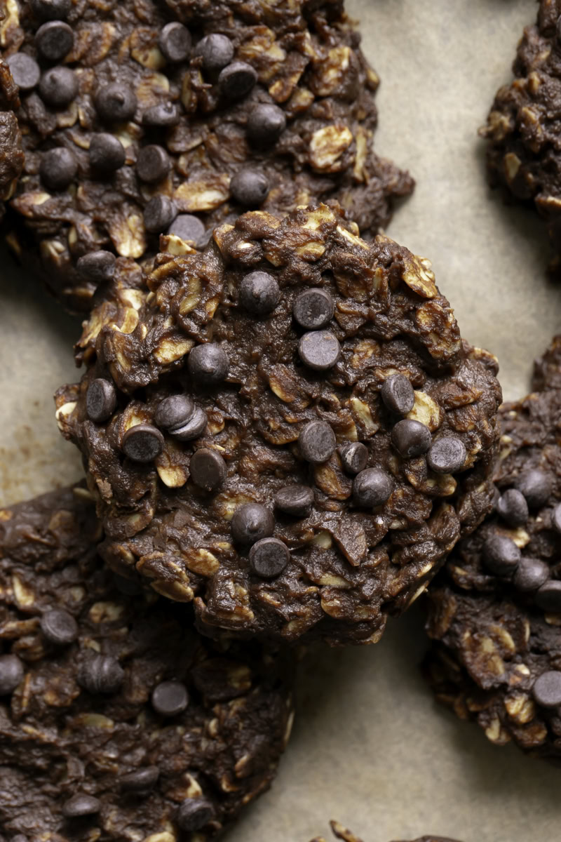 a close up of no-bake pumpkin brownie oatmeal cookies stacked on top of one another