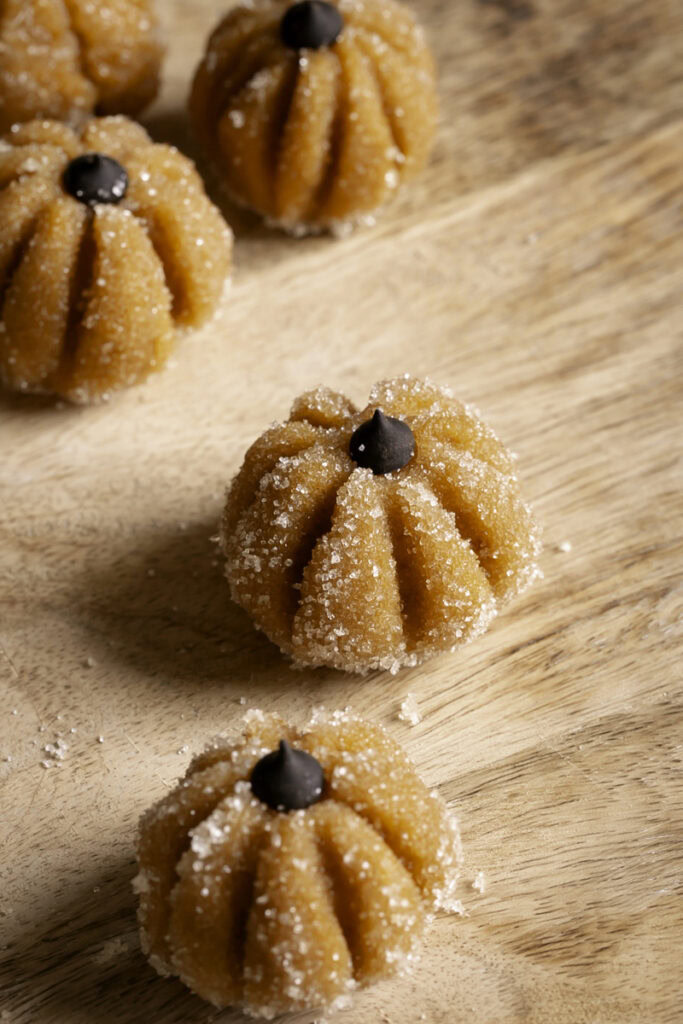 a few Sugared Almond Flour Pumpkin Cookie Dough on a wooden cutting board