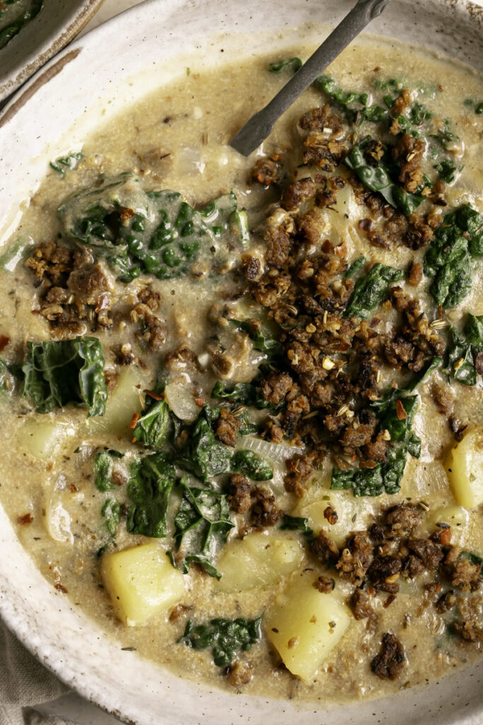 a close up overhead shot of a large bowl of vegan zuppa toscana soup