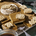 3/4 shot of sheet pan pumpkin pie, some of the pie cut into squares, one piece on a pie server