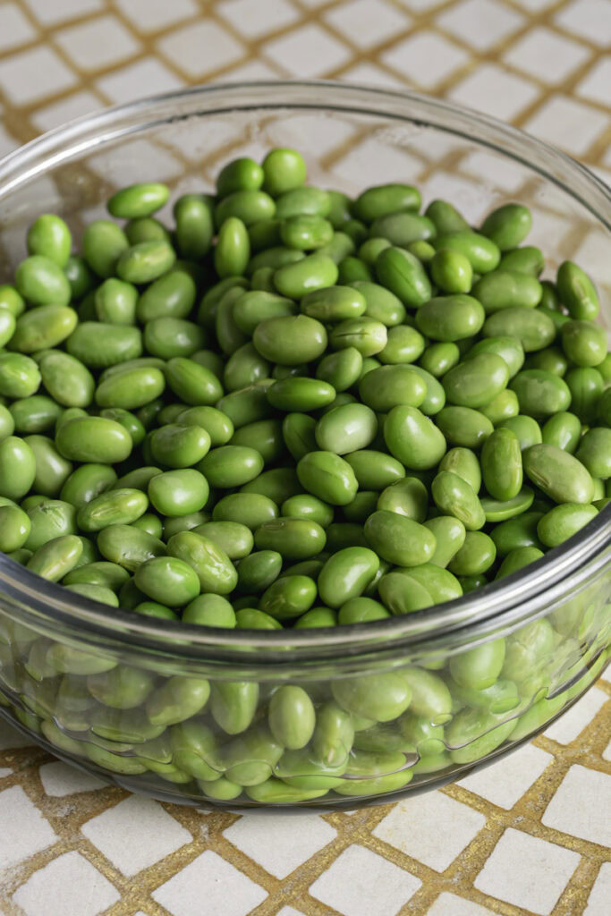 cooked edamame in a glass bowl.