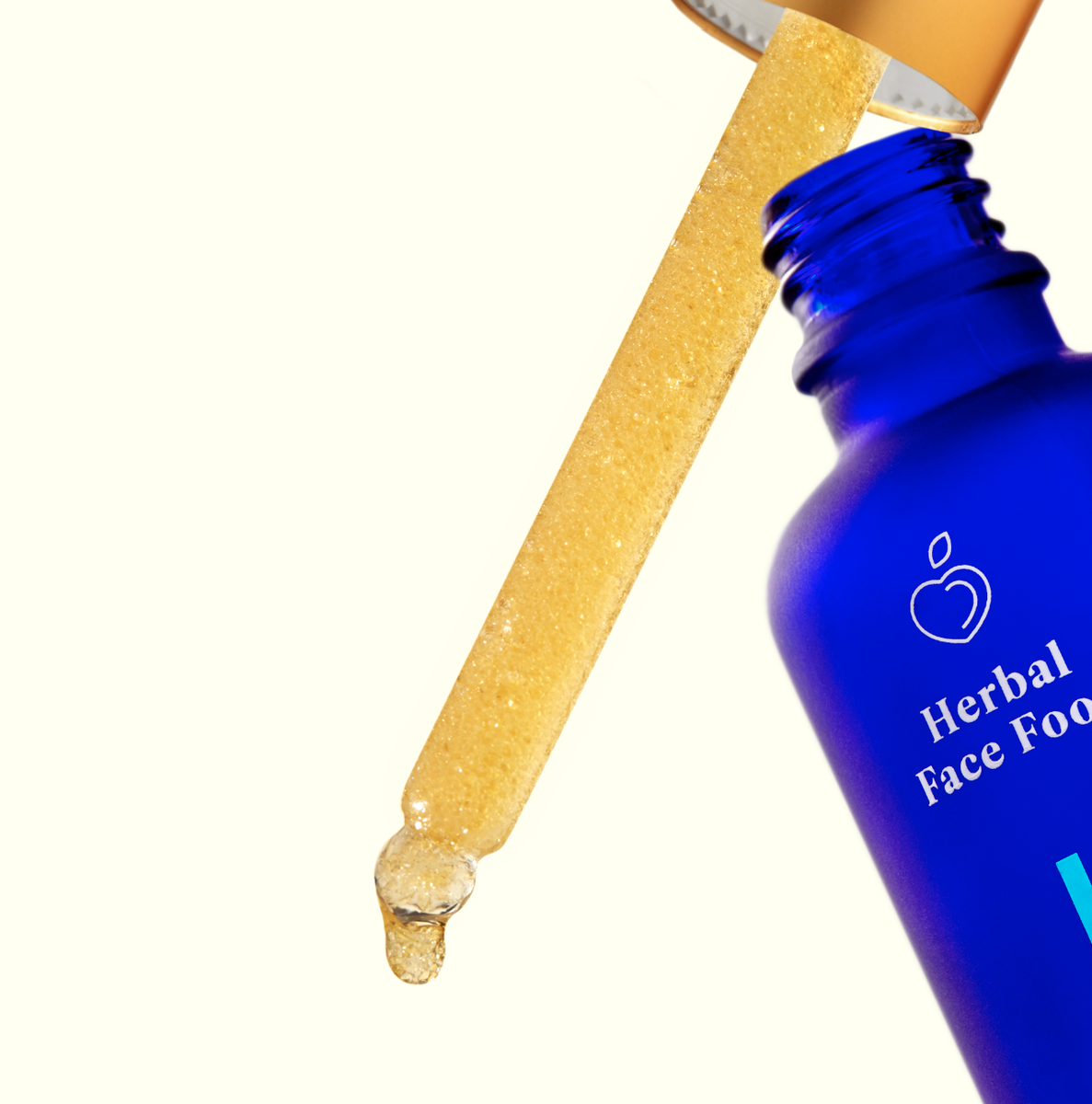 a bottle of herbal face food serum 1 with the dropper out of the bottle and a drop coming out of the dropper
