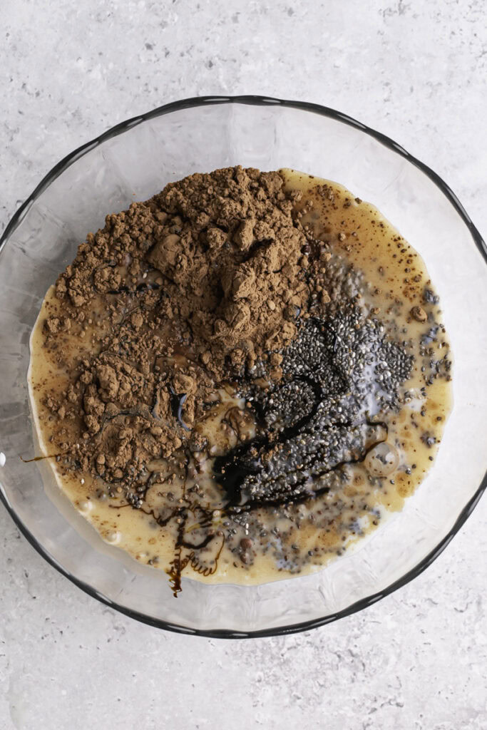 an unmixed photo of all the chia seed pudding ingredients in a glass bowl.