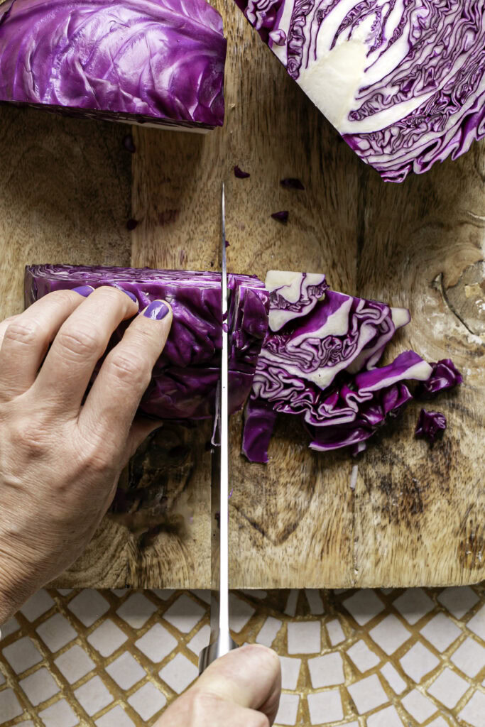 action shot slicing the red cabbage into thin slices.