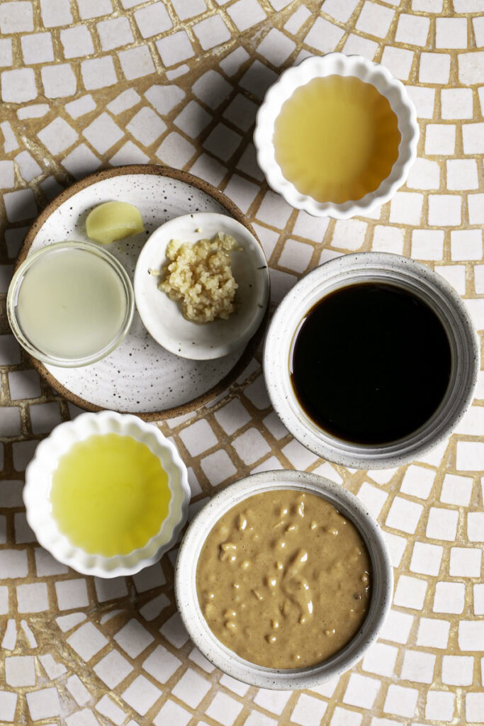 all of the ingredients used to make peanut ginger lime dressing in small bowls.