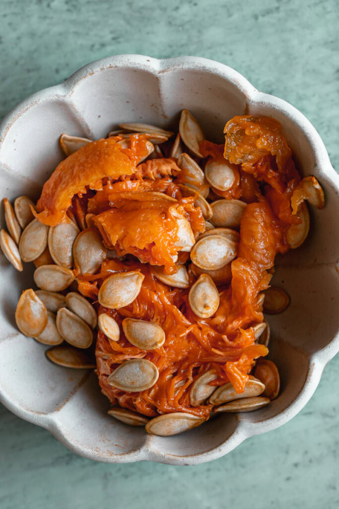 scooped out flesh and seeds of a butternut squash in a small bowl.