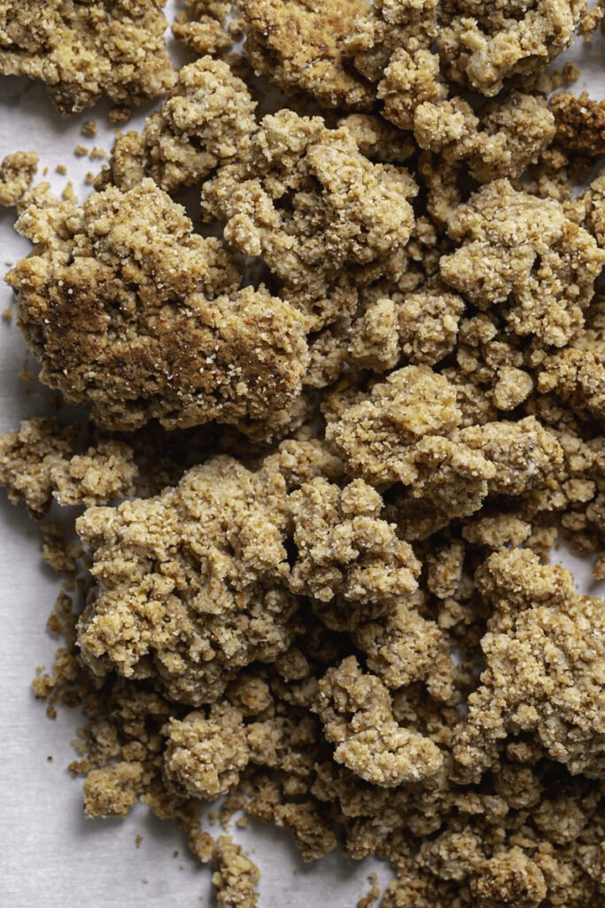 a close up of almond flour biscuit crumble on a piece of parchment paper.