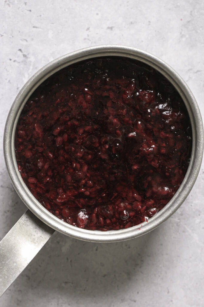 overhead shot of blackberry curd in a small saucepan.