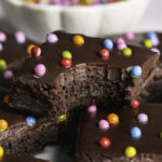 a close up of cosmic brownies, one stacked on top of the others with a bite taken out of it.