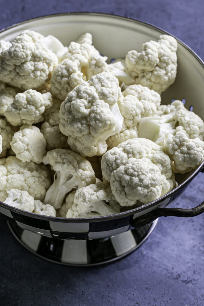 cauliflower florets in a strainer.