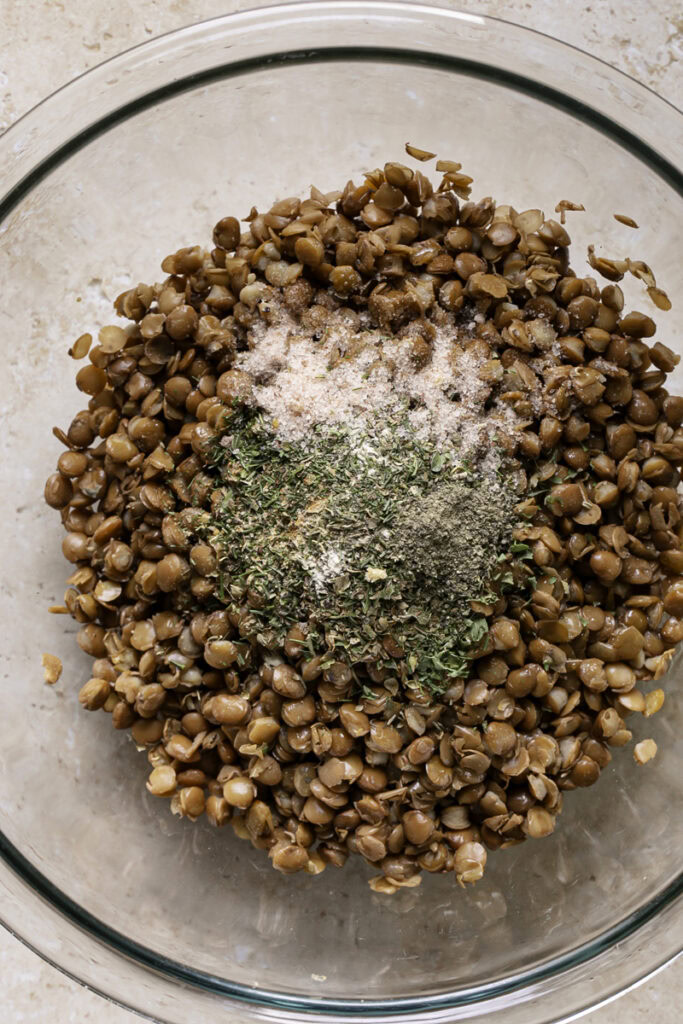 lentils in a glass bowl with the greek spices, unmixed.