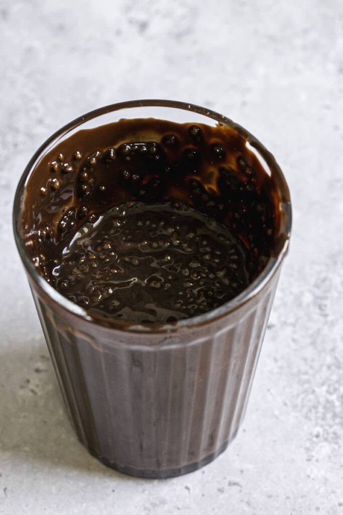 a glass filled with melted chocolate and crispy quinoa.