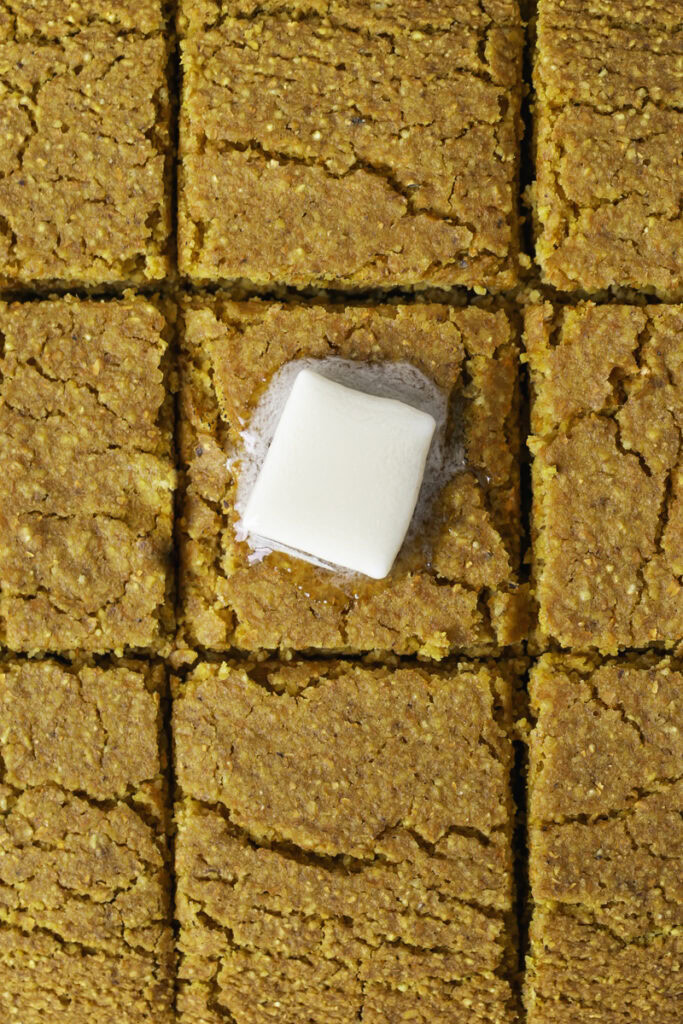 overhead shot of sliced cornbread with a square of butter on the center piece.