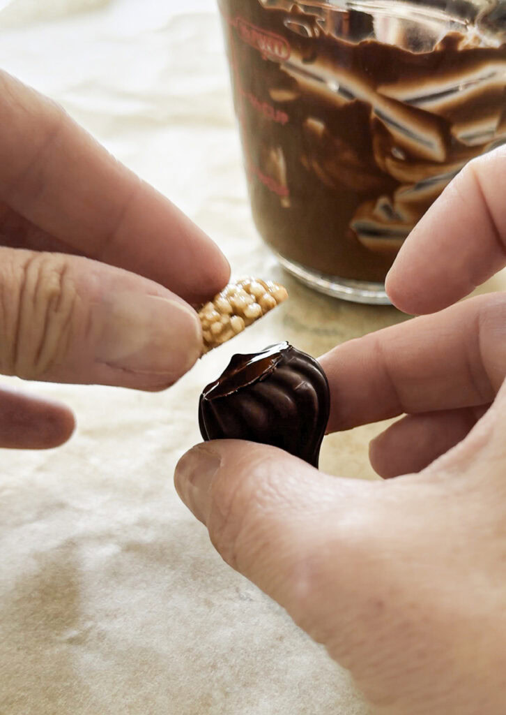 action shot of putting the quinoa cookie on the chocolate kiss.