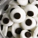 close up shot of chocolate candy googly eyes in a small bowl.