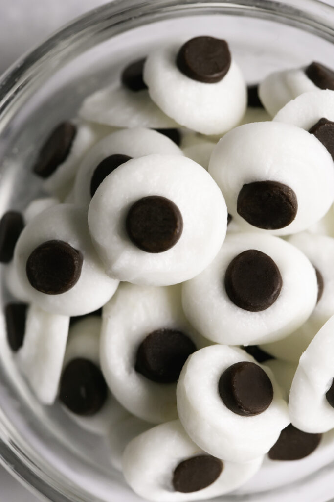 close up shot of chocolate candy googly eyes in a small bowl.