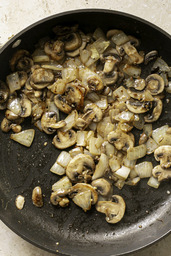 sauteed mushrooms and onions in a skillet.