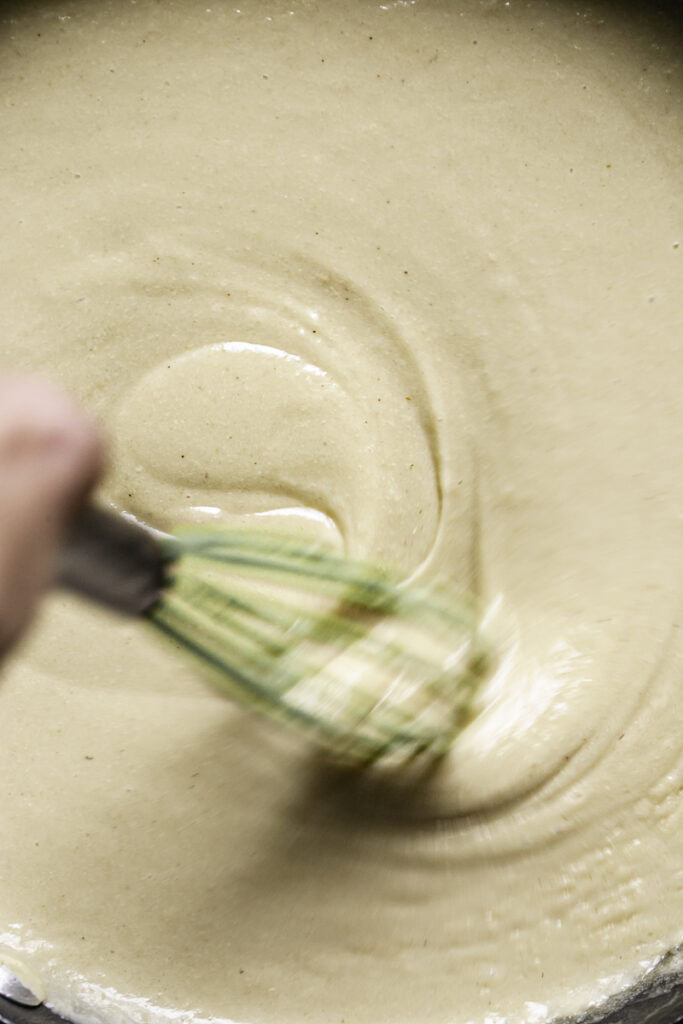 action shot of whisking the roux in a skillet.