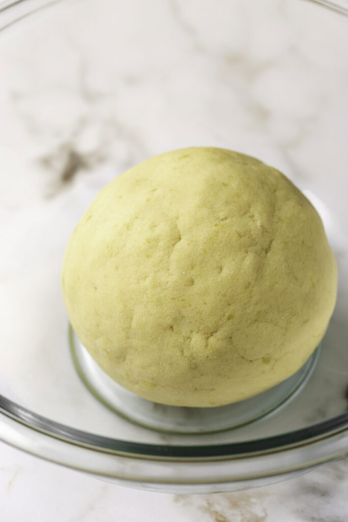 mashed potato dough rolled into a ball in a glass bowl.