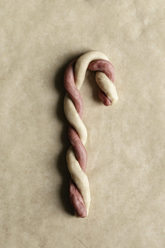 red and white cookie dough shaped into a candy cane.