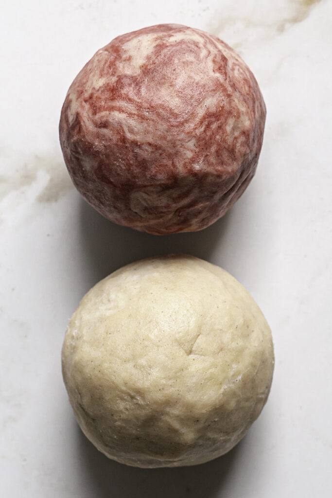 two balls of cookie dough, one red and one white.