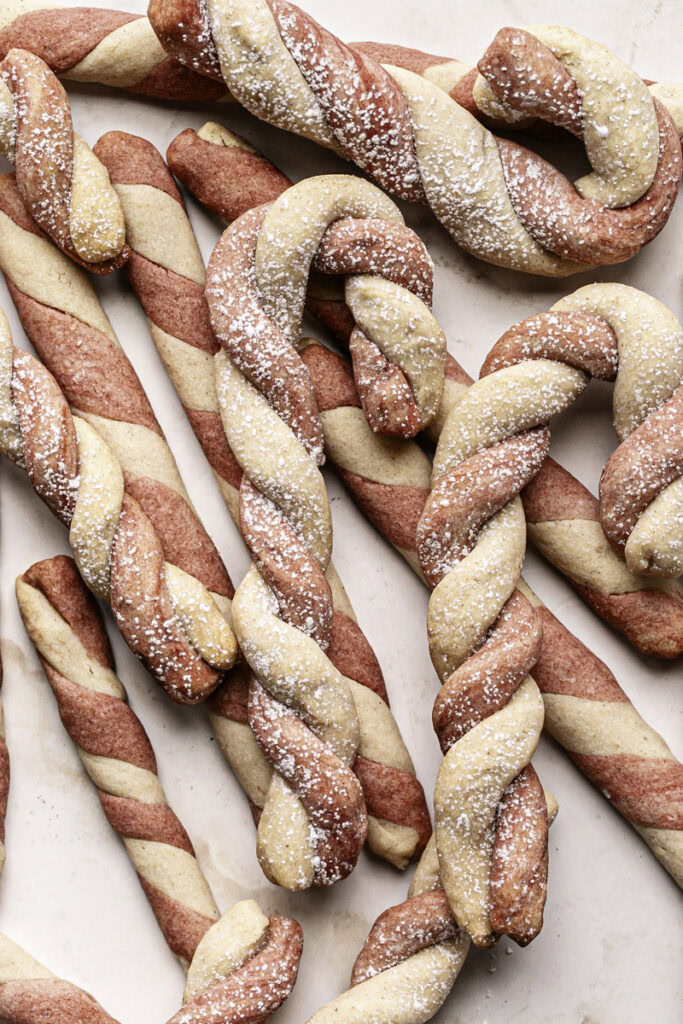 baked shortbread candy cane cookies piled on top of each other.