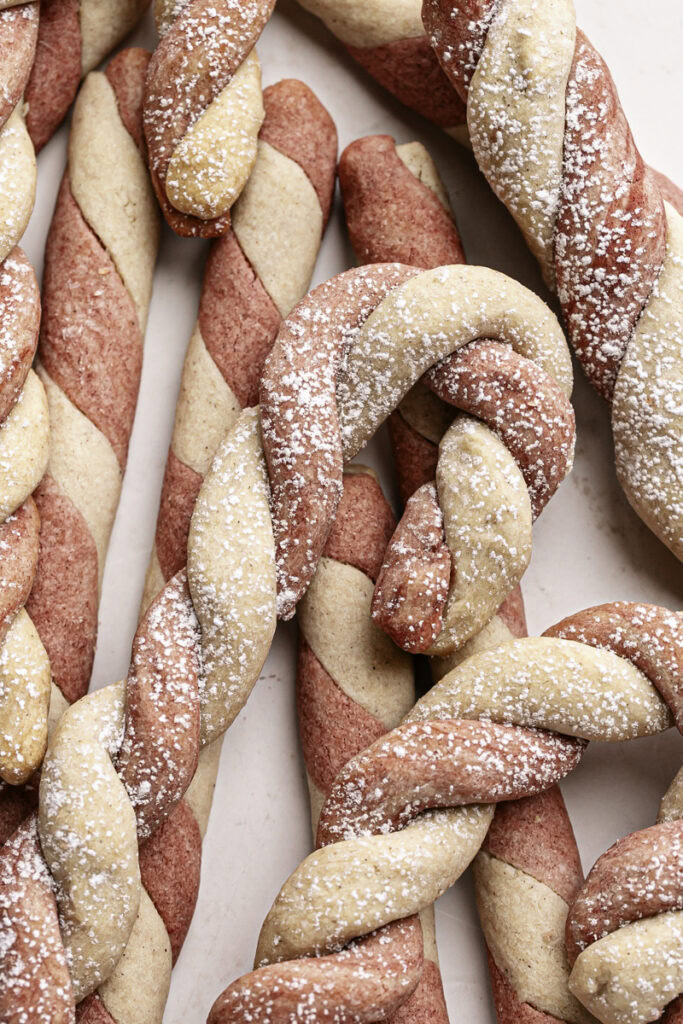 a close up of shortbread candy cane cookies piled on top of each other.