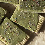 close up of cut slices of a giant frosted matcha pop tart decorated with sprinkles.