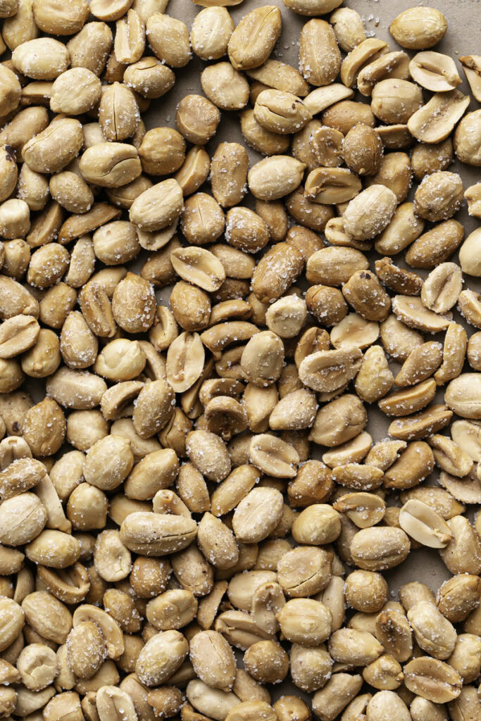 whole roasted peanuts on a baking sheet.