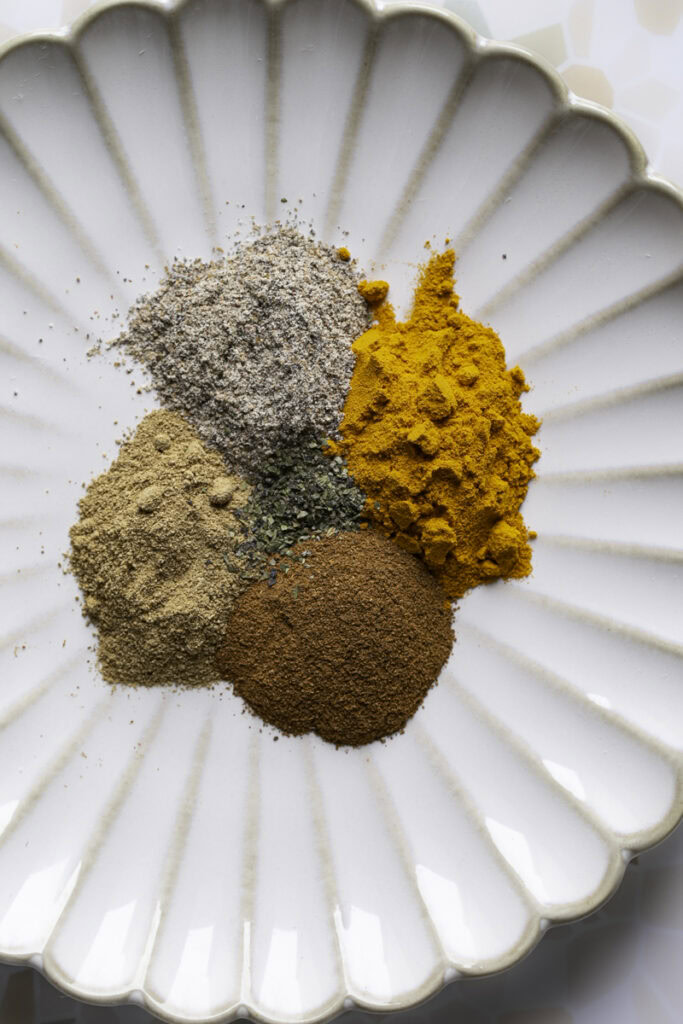 dried spices used to make golden milk on a plate.