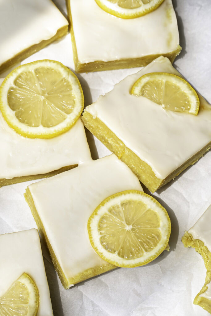 overhead shot of No-Bake Almond Flour Lemon Brownies sliced into squares with slices of fresh lemon.