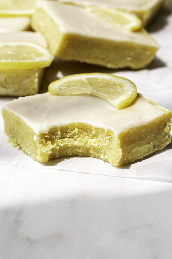 a single lemon brownie with a bite taken out of it.