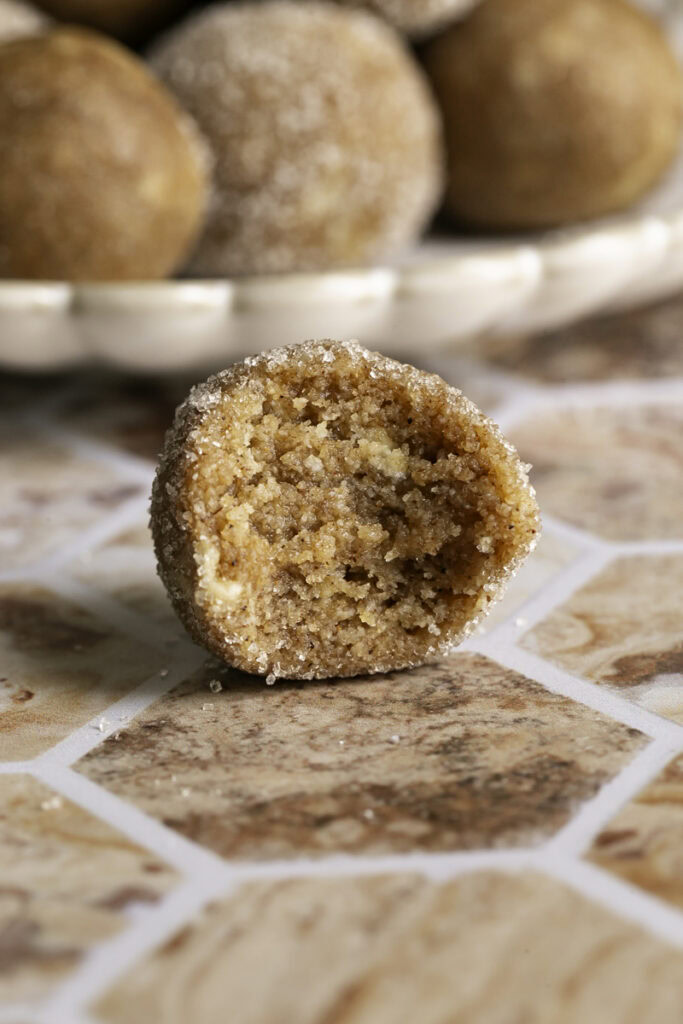 a single churro bite with a bite taken out of it to reveal the texture inside.