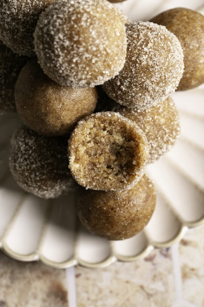 an overhead shot of No-Bake Almond Flour Churro Bites stacked on top of one another, one with a bite taken out of it.