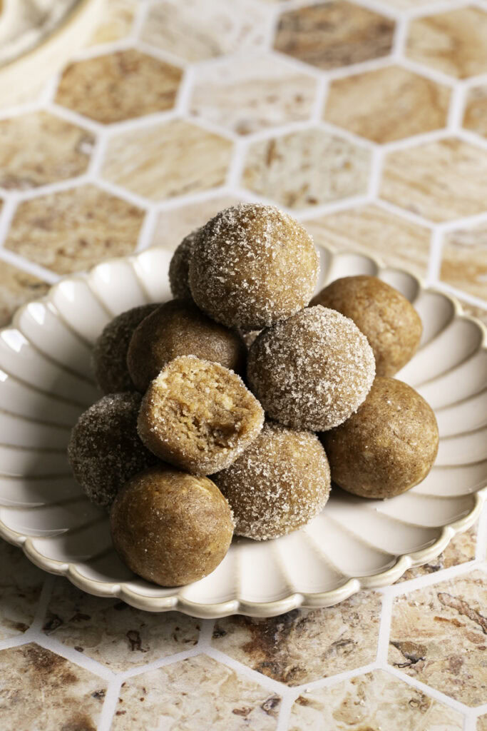 No-Bake Almond Flour Churro Bites stacked on top of one another, one with a bite taken out of it.