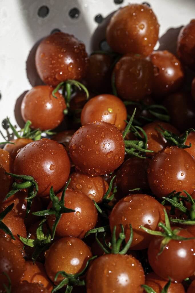 close up of cherry tomatoes in a colander.