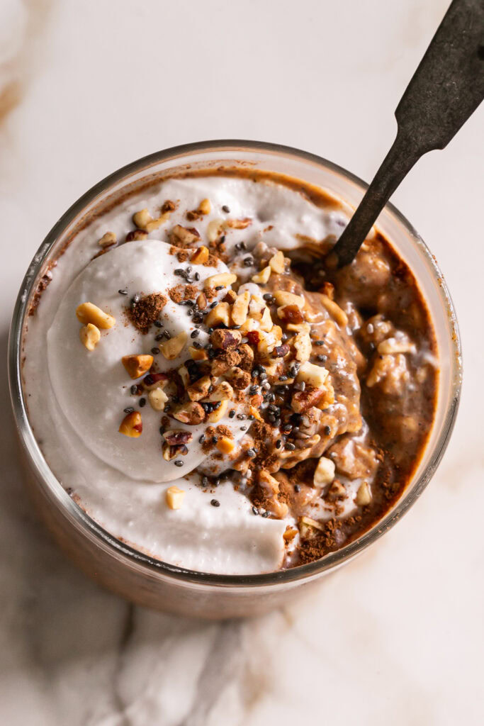 overhead shot of pumpkin spice espresso overnight oats with a spoon in the glass.