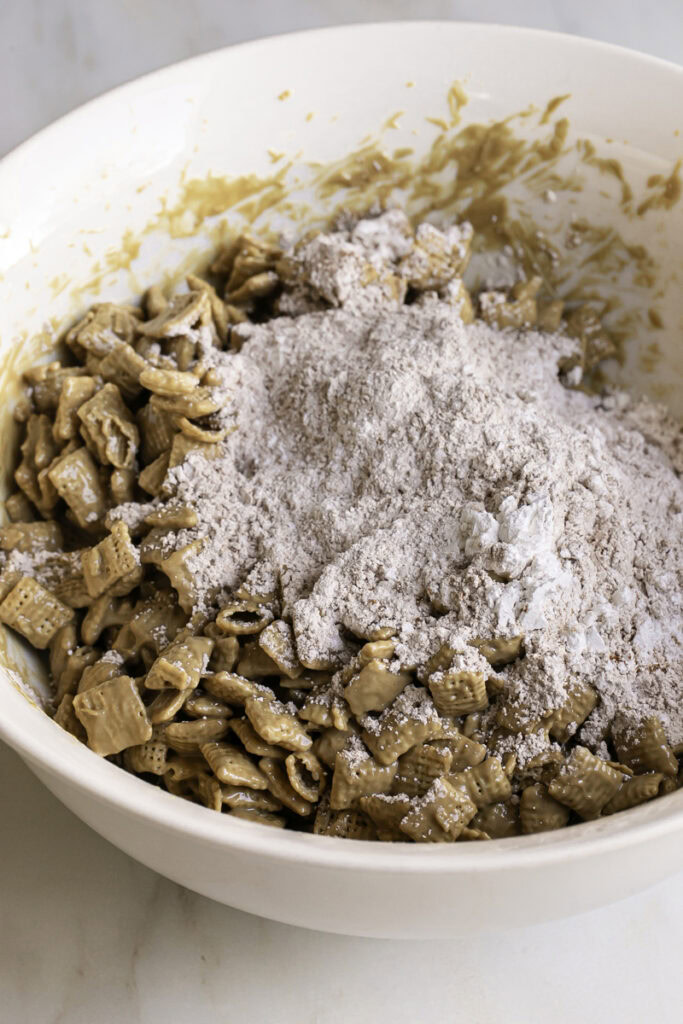 apple pie spiced powdered sugar mixture added to the bowl with the chex cereal.
