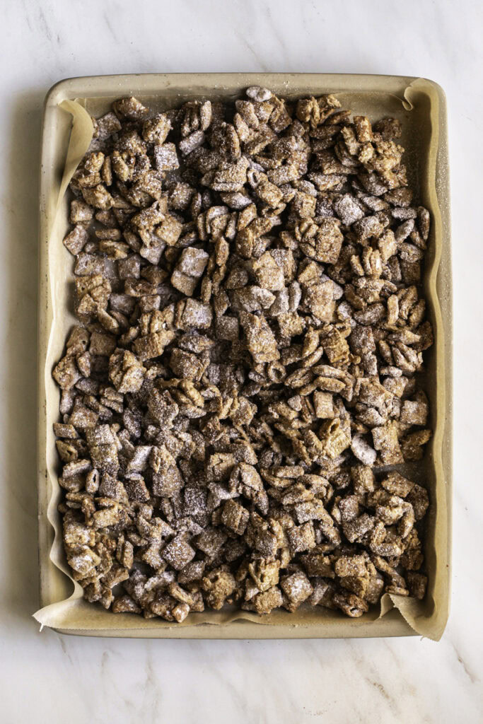 puppy chow on a parchment-lined baking sheet.